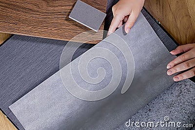 An interior designer's hand selects a palette of sample materials that includes different types Stock Photo