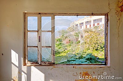 Interior of a desolated house and a window frame with broken glass Stock Photo