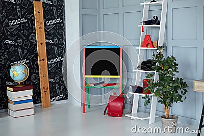 Interior of elementary school. Chalkboard, books, globe, red backpack, pencils and stationery in classroom. Back to school. Classr Stock Photo