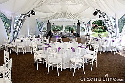 Interior of a event tent decoration ready for guests. Served round banquet table outdoor in marquee Stock Photo