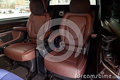 The interior of an expensive business class car inside the rear seats of genuine perforated leather, the central control panel Editorial Stock Photo