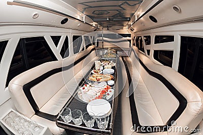 Interior inside the limousine. with sofas and a table covered with snacks for the holiday. Selective focus Stock Photo