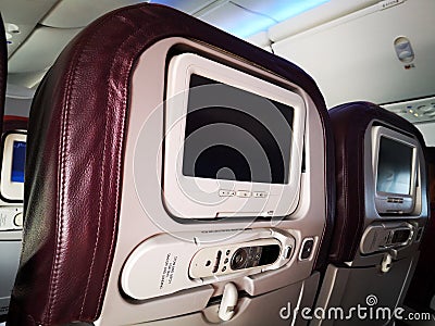 Closeup interior of mini television on flight for passengers on seats inside airplanes view. Stock Photo