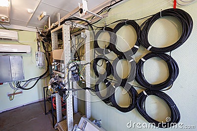 Interior of modern basic station of communications equipment and bights of optic cabeles on the wall Stock Photo