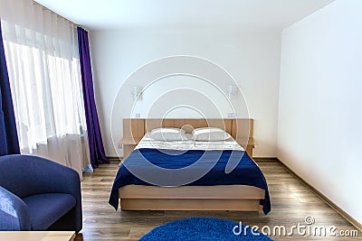 Interior of modern cozy bedroom. Double bed and wall lamps Stock Photo