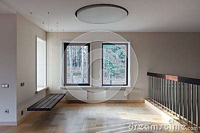 Interior of modern empty space with suspended bench and windows Stock Photo