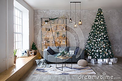 Interior of modern living room with comfortable sofa decorated with Christmas tree and gifts Stock Photo