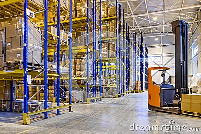 Interior of a modern warehouse storage with rows and goods boxes on high shelves. Pallet truck parking near shelves Editorial Stock Photo