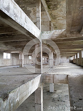 Interior of an old abandoned concrete hall. Empty messy industrial warehouse with several floors and a hole in the floor Stock Photo