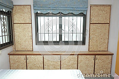 An interior photo of a bedroom with flushed wall wooden wardrobe cardboard cabinets Stock Photo