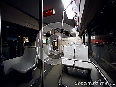 Interior of a public transport bus with empty gray seats and no passengers Stock Photo