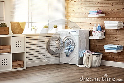 Interior of real laundry room with washing machine at window at Stock Photo
