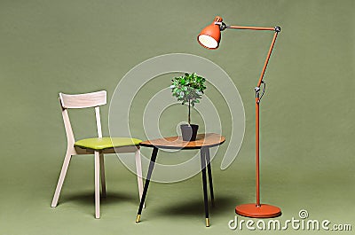 Interior with green chair, lamp, coffee table on green background Stock Photo