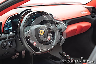 Interior of a red Ferrari 488 sports car with a digital display illuminated in the dashboard Editorial Stock Photo
