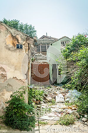 Interior remains of hurricane or earthquake disaster damage on ruined old house in the city with collapsed walls, roof tiles and b Stock Photo