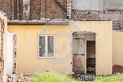 Interior remains of hurricane or earthquake disaster damage on ruined old house in the city with collapsed walls, roof and bricks Stock Photo