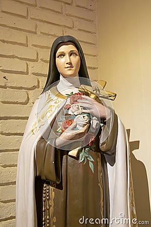 Woman Saint Sculpture Holding Cross Stock Photo