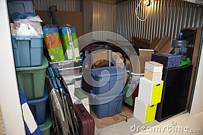 A storage unit full of boxes and plastic tubs Stock Photo