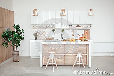 Interior of small white kitchen with fresh fruit, two glasses of orange juice, baguette, red caviar, croissant and Stock Photo