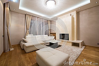 Interior of a specious living room with fireplace and luxury ceiling lights Stock Photo