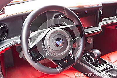 Interior of a sports car Marussia B1 of red color with elegant leather seats, low seating position and steering wheel of a Editorial Stock Photo
