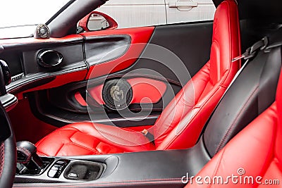 Interior of a sports car Marussia B1 of red color with elegant leather seats, low seating position and steering wheel of a Editorial Stock Photo