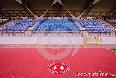 Empty sports stadium; empty spectator stand. Social distancing graphic in foreground Stock Photo