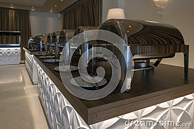 Interior view of a catering room buffet party ready to welcome people for a wedding or celebration event. Chafing dish. Plates and Stock Photo