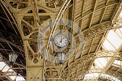 Interior of the Vitebsk railway station. Round Roman clock and glass roof of railway or subway station. Twelve o`clock, seven past Editorial Stock Photo