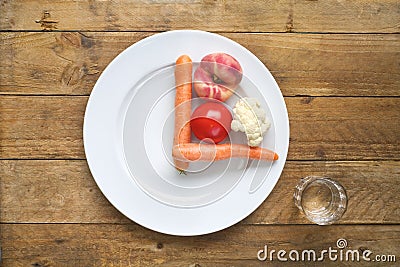 Intermitted fastening, dieting, healthy food concept. Plate with clock face, vegetables,glass of water Stock Photo