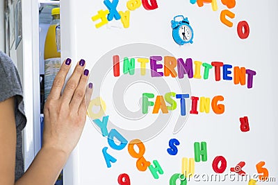 Intermittent fasting diet concept with woman standing in front of fridge starring at food Stock Photo