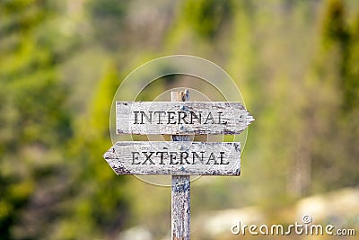 internal external text carved on wooden signpost outdoors in nature. Stock Photo