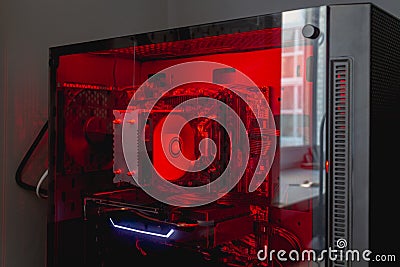 Internal parts of the computer system unit: cooler, hard disk, motherboard, video card in red backlight Stock Photo