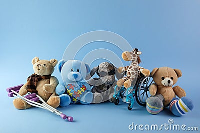 International day of persons with disabilities. Wheelchair with toys sign of different disabilities on blue background. Stock Photo