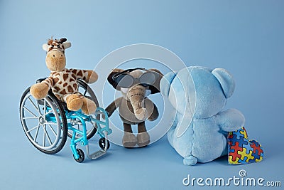 International day of persons with disabilities. Wheelchair with toys sign of different disabilities on blue background. Stock Photo
