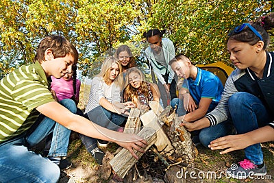 International friends construct bonfire together Stock Photo