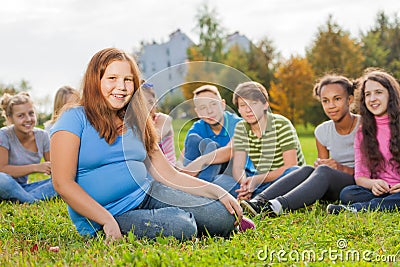 International friends sit together on green meadow Stock Photo