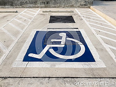 International handicapped wheelchair or Disabled parking symbol painted in bright blue on parking space Stock Photo