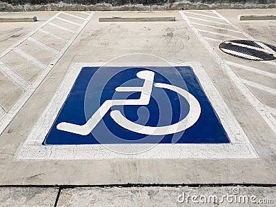 International handicapped wheelchair or Disabled parking symbol painted in bright blue on parking space Stock Photo