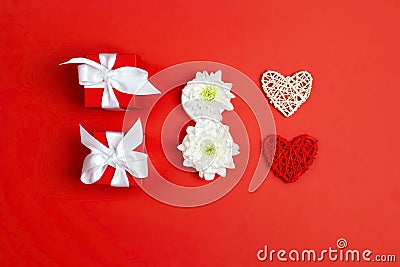 International Women`s Day card with gifts, hearts and chrysanthemum flowers in the form of eight on red background Stock Photo