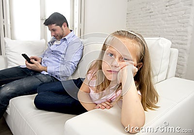 Internet addict father using mobile phone ignoring little sad daughter bored lonely and depressed Stock Photo