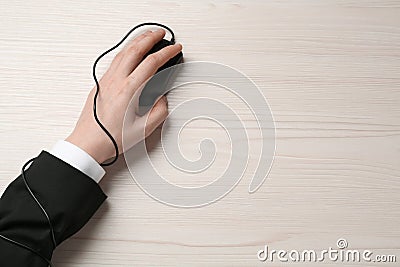 Internet addiction. Top view of man using computer mouse at wooden table, hand tied to device with cable Stock Photo