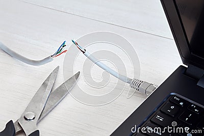 Internet cable, laptop and scissors Stock Photo