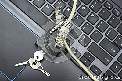 internet cable passing through an open iron lock with keys on a laptop keyboard data protection concept cybercrime Stock Photo