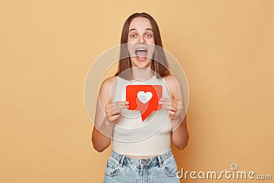 Internet forum communication. Viral video sharing. Heart icon popularity. Amazed overjoyed excited young woman wearing casual Stock Photo