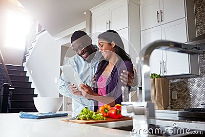 The internet is a great place to find food inspiration. a young couple using a digital tablet while preparing a healthy Stock Photo