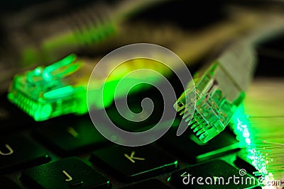 Internet switches on laptop computer keyboard, glowing optical fibres close up shot Stock Photo