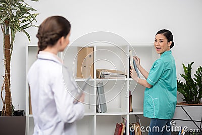 Internist talking with doctor in clinical office, focus on background Stock Photo