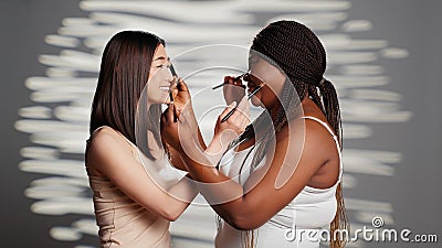 Interracial beauty models giving each other makeovers Stock Photo