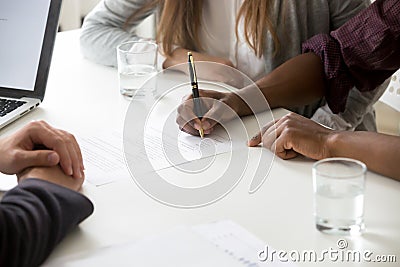 Interracial couple signing financial contract or prenuptial agre Stock Photo
